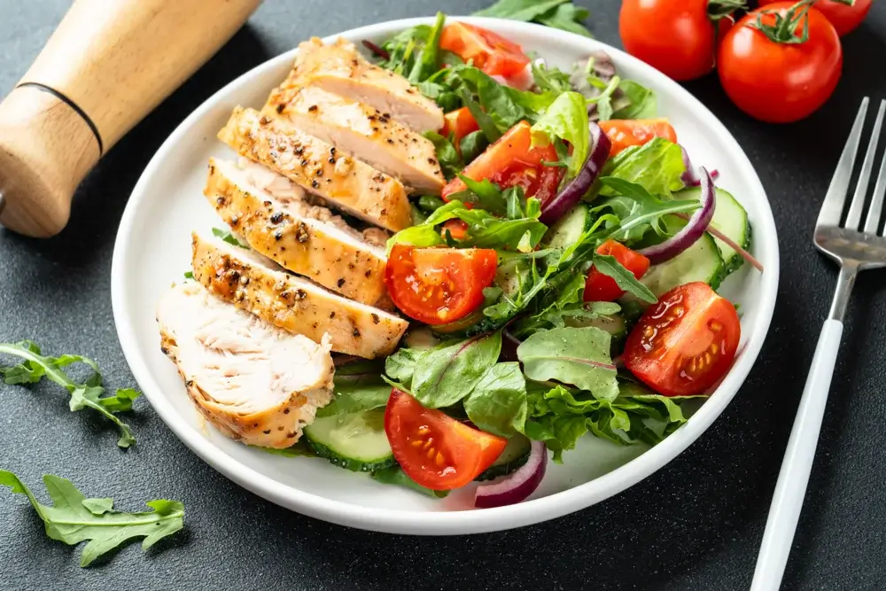 Grilled chicken salad with mixed greens, cherry tomatoes, cucumber,
